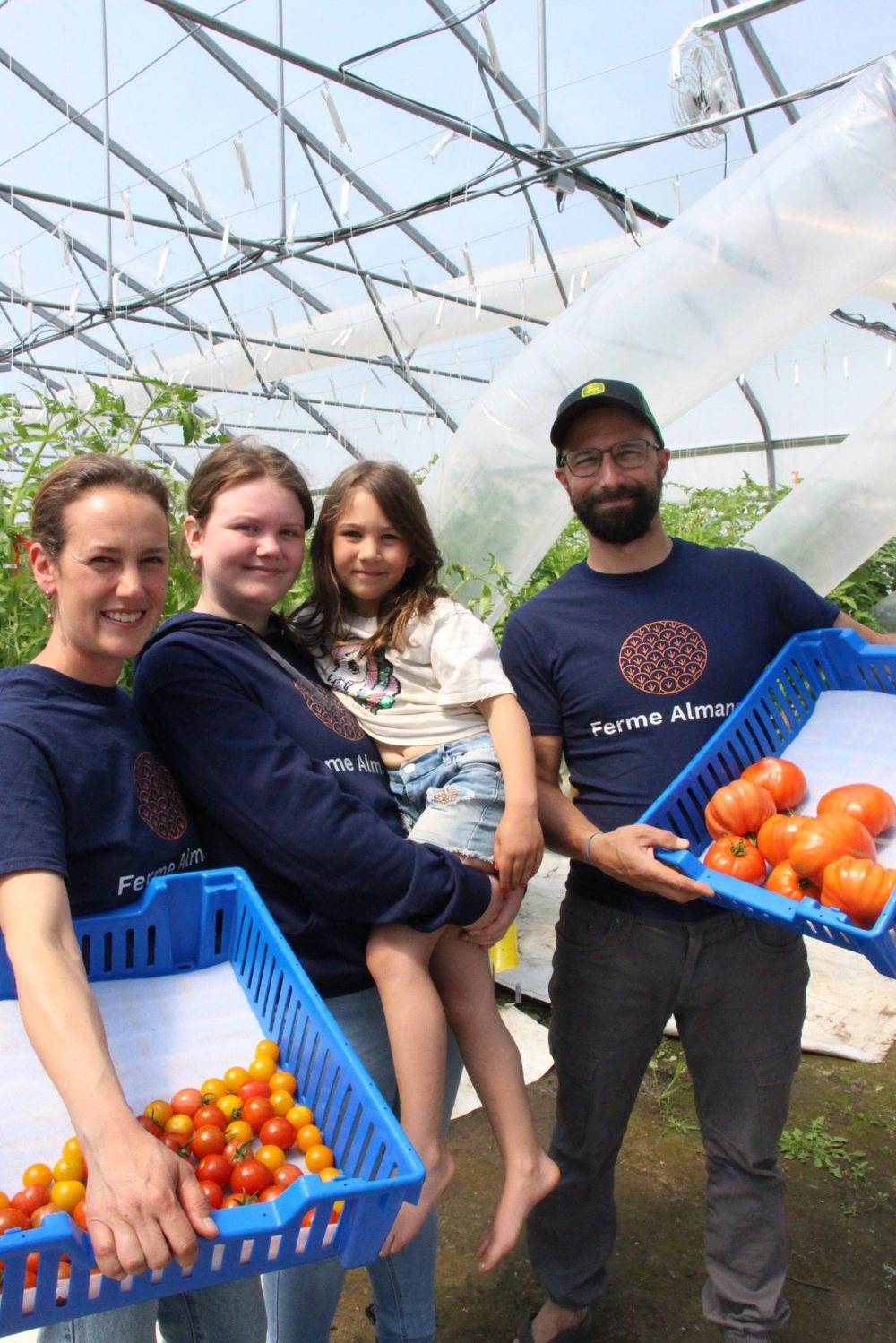 Rosalie, Mathieu et leurs deux filles dans la serre, à la récolte des tomates