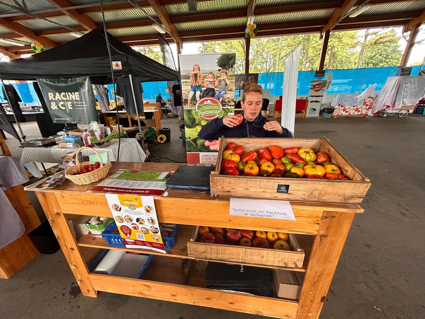 Kiosque de la Ferme Almana dans un marché public avec caisses de tomates